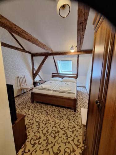 a bedroom with a bed and a tv in a room at Majerovský kaštieľ in Vranov nad Topľou