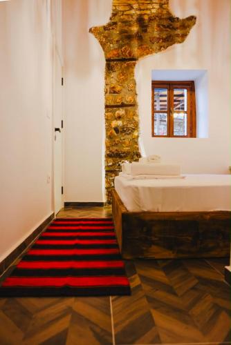 a bedroom with a bed and a stone wall at Stone Villa Berat in Berat