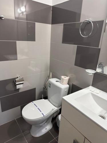 a bathroom with a white toilet and a sink at Hotel Azur in Costinesti
