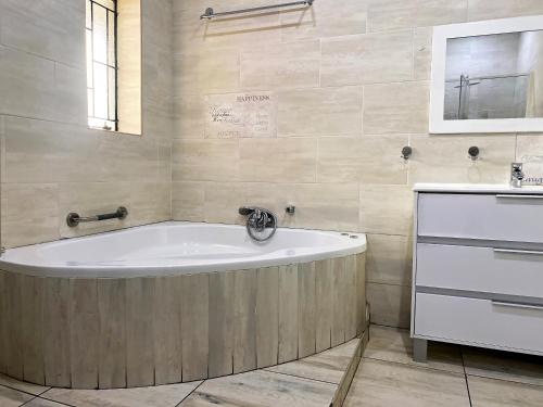 a bathroom with a bath tub and a sink at RAMATA GUEST HOUSE in Pretoria