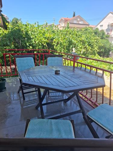 a picnic table and chairs on a patio at Radovići,Luštice in Radovici