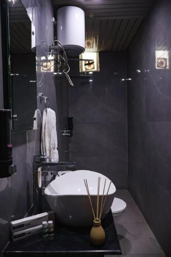 a bathroom with a white sink and a toilet at Coco House in Greater Noida
