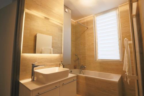 a bathroom with a sink and a tub and a mirror at Casa Calma in Esztergom