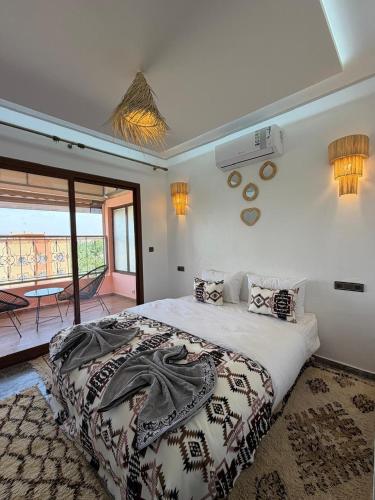 a bedroom with a large bed and a balcony at Qamar Mgouna Hotel in El Kelaa des Mgouna