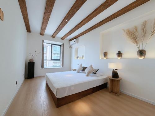 a white bedroom with a bed and a window at Lucky Designer Residence Near Bell Tower & City Wall in Xi'an