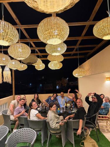 a group of people sitting at a table under chandeliers at Qamar Mgouna Hotel in El Kelaa des Mgouna