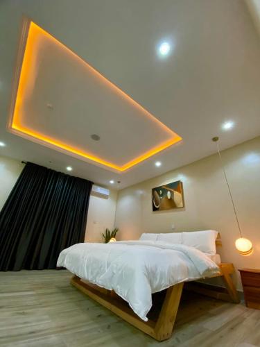 a large bedroom with a large bed with white sheets at The Crest Triplex in Ikeja