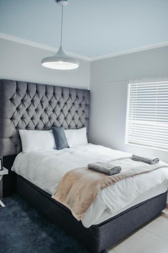 a bedroom with a large bed with a large headboard at High tide complex in Langstrand