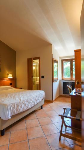 a bedroom with a bed and a tiled floor at Locanda La Scottiglia in Seggiano