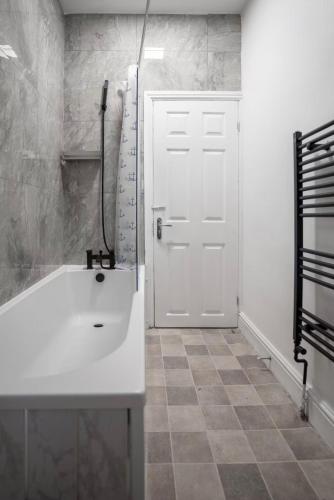 a bathroom with a white sink and a white door at Mauldeth Shared House in Manchester