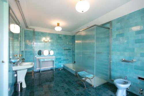 a blue bathroom with a sink and a toilet at Villa Inella in Oggiono