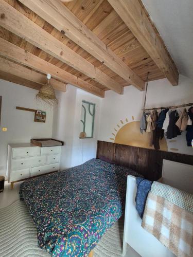 a bedroom with a bed and a wooden ceiling at Maison en bord de rivière in Cheffes-sur-Sarthe