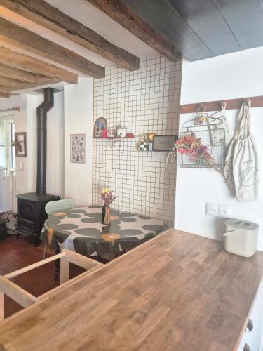 a living room with a table and a stove at Maison en bord de rivière in Cheffes-sur-Sarthe
