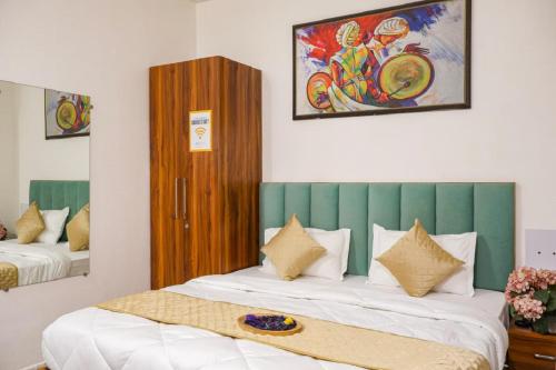 a bedroom with two beds with a green headboard at Coco House in Greater Noida