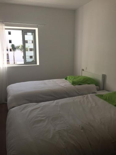 two beds in a room with a window at Iken Park Agadir in Agadir
