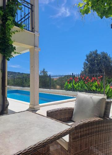a patio with a table and chairs next to a pool at Apartments Neli in Vinišće