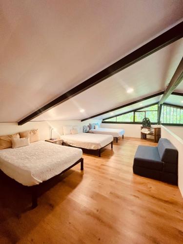 a large room with two beds and a couch at Casa Rural Los Almendros - Tarcoles in Capulín