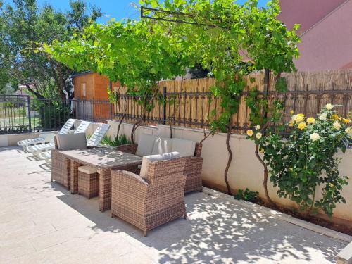 a patio with a table and chairs and a fence at Apartments Neli in Vinišće