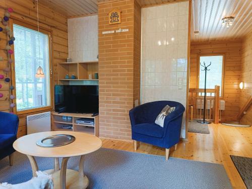 a living room with a blue chair and a table at Kärpänpesä B in Syöte