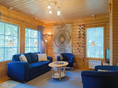 a living room with a blue couch and a table at Kärpänpesä B in Syöte
