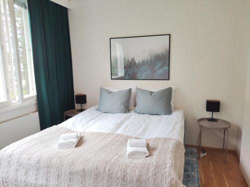 a bedroom with a bed with two towels on it at Kaksio lähellä keskustaa in Iisalmi
