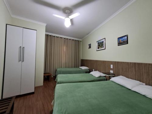 a hotel room with three beds and a closet at Apartamento São Pedro SP in São Pedro