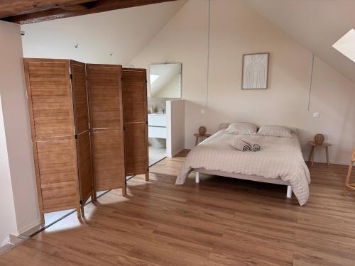 a bedroom with a bed and some wooden cabinets at Sous les combles in Hambach