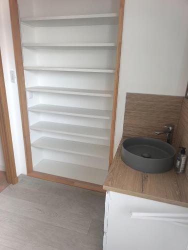 a kitchen with a cupboard with a sink in it at Maison près de la plage in Sangatte