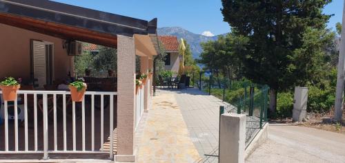 a house with a white fence and a porch at Marija Holiday Home in Sućuraj