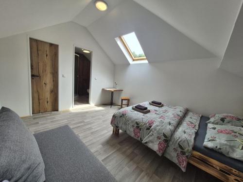 a bedroom with a bed and a window and a table at Pension Alex in Benecko