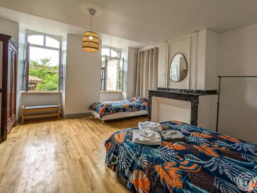 a bedroom with a bed and a table in it at Le Clos d'Artagnan in Valcabrère