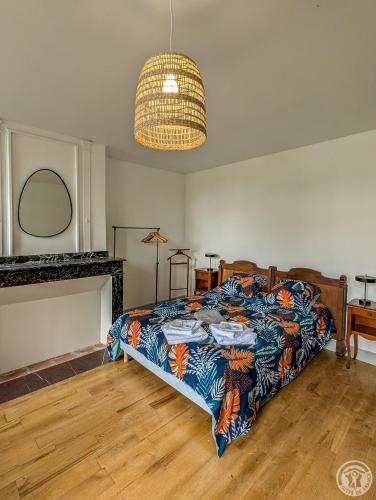 a bedroom with a bed with a colorful blanket at Le Clos d'Artagnan in Valcabrère
