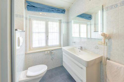 a bathroom with a sink and a toilet and a mirror at Micheli Hermann Obst- und Weinbauernhof mit "Südtirol Alto Adige Guest Pass - Mobilcard" in Caldaro