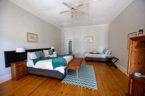 a bedroom with a bed and a ceiling fan at Beyond Cui Bono - Travel Addo Group in Sunland