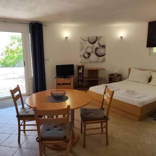 a bedroom with a bed and a table and chairs at Apartments Ada in Primošten