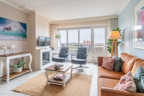 a living room with a couch and a table and chairs at Appartementencomplex Juliana 148 in De Koog
