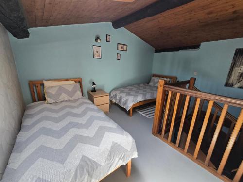 a bedroom with two twin beds and a staircase at Le rouge Robin in Fougax-et-Barrineuf