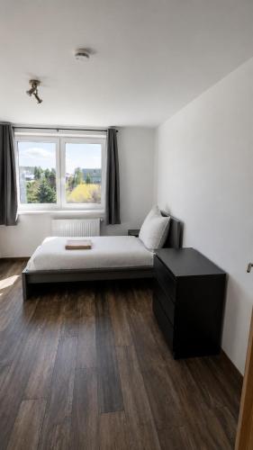 a bedroom with a bed and a dresser and a window at Monteurwohnungen in Markranstädt in Markranstädt