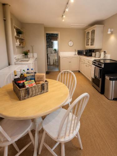 a kitchen with a wooden table with chairs and a tableasteryasteryasteryasteryastery at Paddock View Loft Countryside Retreat in Thornhill