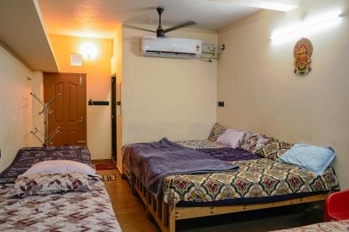 a room with two beds and a couch in it at AnanthaSayanam Homestay Near Sri Padmanabha Swamy Temple in Trivandrum