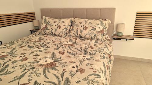 a bedroom with a bed with a floral bedspread at Studio Miška in Bohinjska Bela