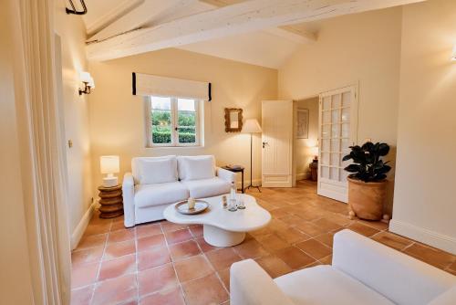 a living room with a white couch and a table at La Bastide de Saint Tropez in Saint-Tropez