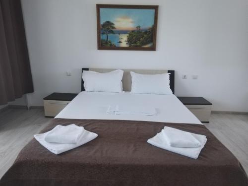 a large white bed with two white towels on it at Casa Ștefan in 2 Mai