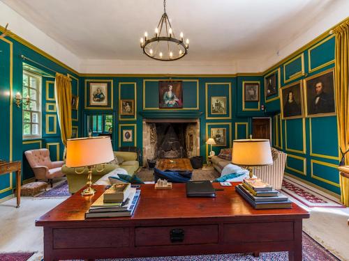 a living room with a table and a fireplace at Lickleyhead Castle in Insch