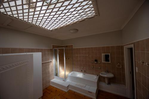 a bathroom with a tub and a sink and a skylight at Beyond Cui Bono - Travel Addo Group in Sunland