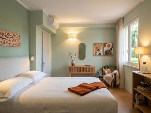 a bedroom with a white bed and a window at My Tuscany Green Apartment in San Quirico dʼOrcia