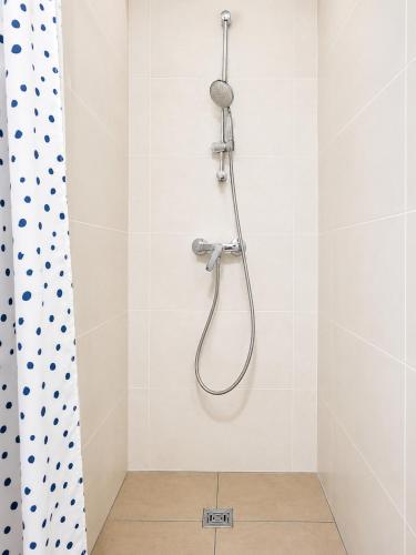 a shower with a shower head on a wall at Monteurwohnungen in Markranstädt in Markranstädt