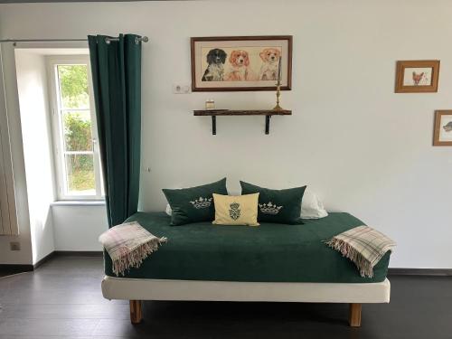 a bedroom with a green bed with a window at Logis de la Jordronnière, Chambre d hôtes in Sigournais