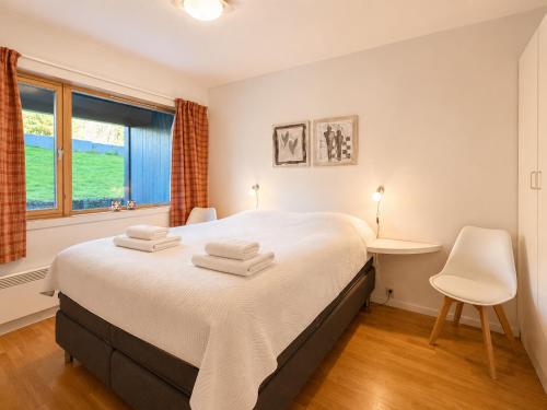 a bedroom with a bed and a desk and a window at Central Apartment in Geilo in Geilo