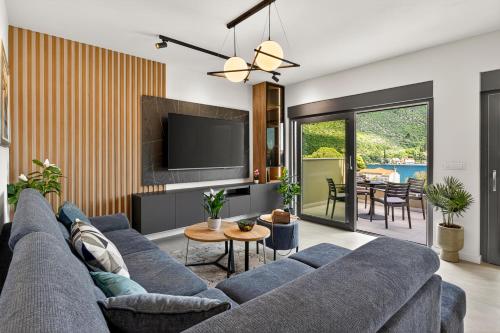 a living room with a blue couch and a tv at Alba Azzura in Zaton